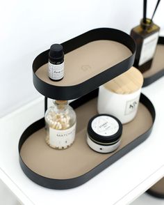 two black trays with bottles and containers on them