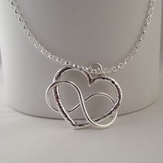 "Stunning Hand Crafted Solid Silver 925 Infinity Heart Pendant This stunning and unusual pendant is handmade by Little Bird Studio 22 and is hand crafted from solid sterling silver 925. The pendant is beautifully inspired and combines a heart..the symbol of love with infinity. It is approx. 25mmx25mm The design is beautiful in its simplicity. I have other unique jewellery available so please check out my other items This on trend pendant would make a gorgeous gift or beautiful treat for yourself The design is truly unique and the pendant comes complete with an 18\" solid sterling silver chain, it will also come with a lovely handmade unbleached cotton gift pouch. Please feel free to ask any questions you may have and I will do my best to answer as swiftly as possible. I will happily make p Handmade Double Heart Jewelry For Anniversary, Unique Silver Necklaces For Valentine's Day, Unique Silver Necklace For Valentine's Day, Unique Silver Heart Necklace For Gift, Handmade Open Heart Jewelry For Anniversary, Sterling Silver Infinity Heart Necklace For Anniversary, Handmade Silver Heart Necklace For Mom, Nickel-free Silver Infinity Jewelry, Silver Infinity Heart Necklace For Anniversary