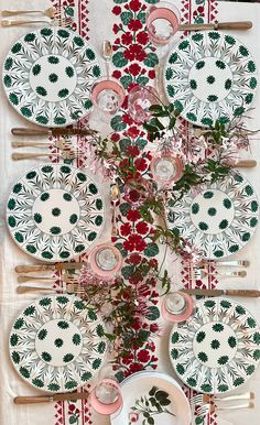 a table topped with plates covered in green and red designs