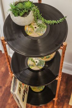 an old record player turned into a planter on top of a three - tiered shelf