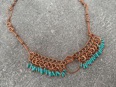 This gorgeous beaded fringe collar bib necklace features intricate wire wrapped details in high-quality pure copper. All components are 100% handmade for a unique statement necklace found nowhere else. This style reflects Southwestern and tropical vibes-- an Art Nouveau-inspired design borrowing ornate filigree accents and organic shapes that give it a vintage feel. Flaunt this beautiful fresh boho look to compliment your style and elevate any outfit. Give as a memorable unique gift to the favorite woman in your life:  For Mother's Day, anniversary presents, Christmas gifts, birthday gifts, graduation and bachelorette parties. ## Sizing Total length is 18 inches. ## Materials Every item is 100% handmade and one-of-a-kind. The wire-wrapped raw copper jewelry is oxidized and polished to beau Handmade Turquoise Copper Wire Necklace, Handmade Turquoise Necklace With Copper Wire, Turquoise Necklace With Copper Wire, Adjustable Bohemian Copper Necklace, Artisan Wire Wrapped Beaded Necklaces For Festivals, Green Bohemian Copper Wire Necklace, Bohemian Beaded Choker, Handmade Turquoise Bohemian Bib Necklace, Bohemian Wire Wrapped Choker For Festivals