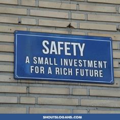 a blue sign mounted to the side of a brick building that says, safety a small investment for a rich future