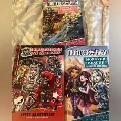 four monster high books are laying on a bed