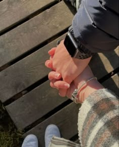 two people holding hands while sitting on a bench