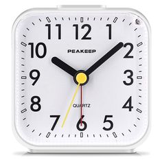 a white clock with yellow hands and numbers on the face is shown in front of a white background