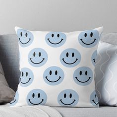 a blue and white pillow with smiley faces on it