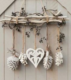 an assortment of ornaments hanging from a wooden frame on a wall in front of a barn