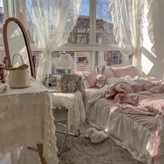 a bed room with a neatly made bed next to a large window and a table