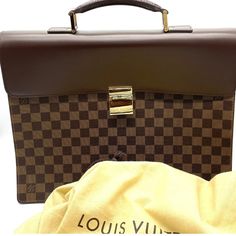 Up for sale is a stunning vintage Louis Vuitton Damier Ebene Altona PM Briefcase. This unisex piece is brand new and has the tags inside the interior Pocket. This classic piece comes in a rich brown color with a gold buckle closure. The briefcase is made of high-quality leather and features the iconic Louis Vuitton brand, making it a must-have for any fashion enthusiast. This briefcase model is part of the Louis Vuitton Damier product line and has a retail price of $3200. It's perfect for both m Important Documents, Fashion Enthusiast, Louis Vuitton Damier Ebene, Damier Ebene, Vintage Louis Vuitton, High Quality Leather, Timeless Pieces, Louis Vuitton Damier, Brown Color