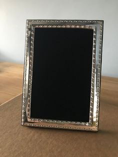 a silver frame sitting on top of a wooden table