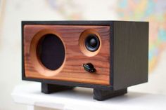 a wooden speaker mounted to the side of a wall with two black knobs on it