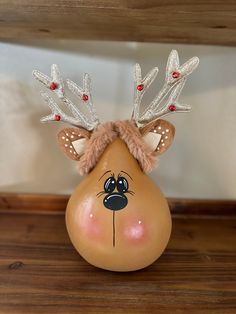 a plastic reindeer head on top of a wooden table next to a white and brown wall