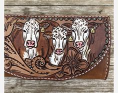 three cows are depicted on the brown leather wallet