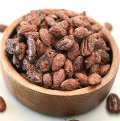 a wooden bowl filled with nuts on top of a table