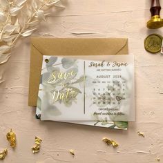 a wedding save the date card on top of a table with gold confetti