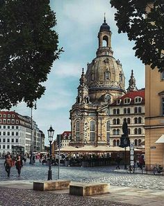 a large building with a clock tower on it's side in the middle of a town square