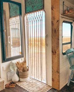 the inside of a tiny house with a door open and a chair next to it