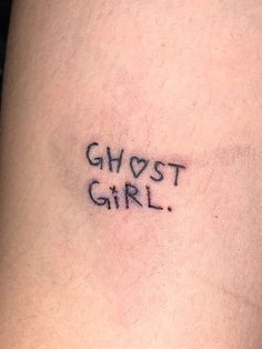 a tattoo saying ghost girl on the back of a woman's thigh, with words written in cursive font