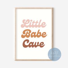 a framed print with the words little babe cave in brown and pink on it's side