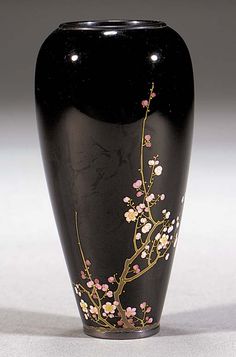 a black vase with flowers painted on it