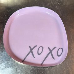 a pink plate with the word xoxo written on it in cursive writing