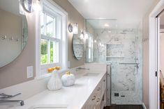 a large bathroom with two sinks and a walk - in shower next to a dining room table