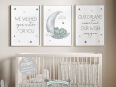 a baby crib with three posters on the wall