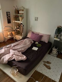 an unmade bed sitting on top of a hard wood floor