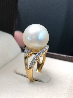 Genuine SOUTH SEA PEARL, absolutely natural color and luster, 14 mm in size, surrounded by 17 pieces of hand-set E/VVS superb quality diamonds, weighting at 0.47 carat. Set in handcrafted, one of a kind 18K solid white yellow ring, weighting at 6.0 grams. The pearl is naturally cultured from South Australia Sea, its luster is extra fine, AA+ grade with 95% clean surface. SUGGESTED RETAIL PRICE: $9,800 The ring is hand crafted to a high standard and is NOT mass machine produced and is brand new c Luxury White Pear-shaped Diamond Ring, Luxury Pear-shaped Diamond Ring Gift, Elegant Pear-shaped Diamond Ring With Gemstone, Elegant Yellow Gold Pear-shaped Ring, Luxury White Pear Shaped Rings, Elegant Yellow Gold Pear Shaped Rings, Elegant Pear-shaped Yellow Gold Rings, Elegant Pear-shaped Diamond Ring Gift, White Pear-shaped Diamond Ring As Gift