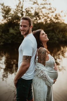 a man and woman standing next to each other near water