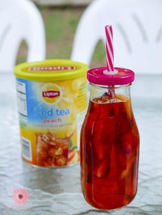 two jars filled with iced tea sitting on top of a table