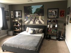 a bed room with a neatly made bed and pictures on the wall