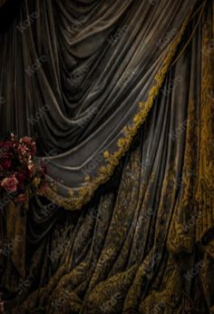 a bouquet of flowers sitting on top of a table next to a drape covered curtain