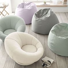 four bean bag chairs sitting on top of a wooden floor