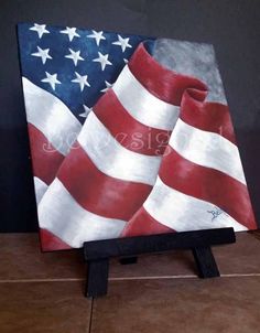 an american flag painted on top of a wooden easel