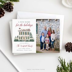 a christmas card with an image of a family in front of a house and pine cones