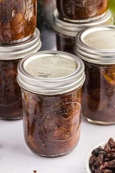 several jars filled with raisins sitting on top of a table