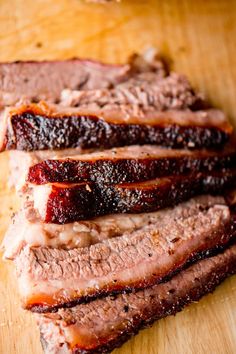 sliced meat sitting on top of a wooden cutting board