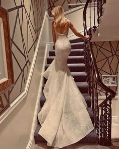 a woman in a wedding dress walking down some stairs