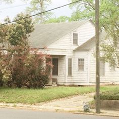 a white house sitting on the side of a road