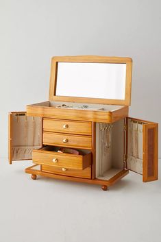 a wooden jewelry box with two drawers and a mirror