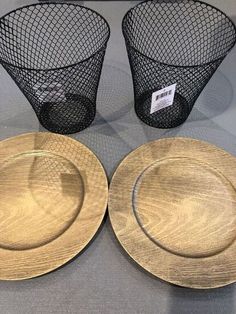 three gold plates and two black wire baskets