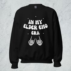 The In My Elder Emo Era unisex sweatshirt is perfect for anyone who grew up in the pop punk and emo scene and is still fully immersed in the culture today. Millennials are especially going to love this if they're still obsessed with emo, pop punk, or alternative music and culture. With a bold design and comfy fit, this sweatshirt is the perfect way to show that it was never a phase. Wear it to concerts, festivals, and more to keep you warm and looking cool.  The In My Elder Emo Era sweatshirt is Unisex Crew Neck Sweatshirt With Band Merch, Punk Letter Print Sweatshirt For Concert, Punk Style Letter Print Sweatshirt For Concert, Grunge Letter Print Sweatshirt For Concert, Emo Style Crew Neck Sweatshirt With Letter Print, Winter Emo Sweatshirt With Letter Print, Alternative Style Crew Neck Sweatshirt For Alternative Fashion, Grunge Graphic Print Sweatshirt For Alternative Fashion, Edgy Relaxed Fit Sweatshirt With Letter Print