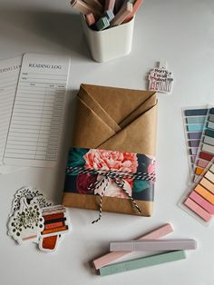 an open envelope sitting on top of a table next to some markers and pencils