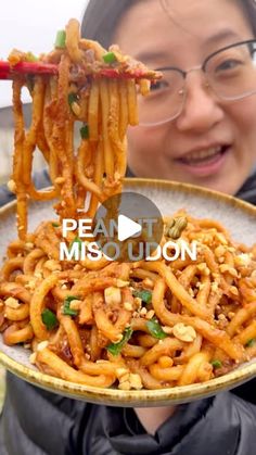 a woman holding a plate full of noodles with chopsticks in her hand and the caption reads peanut missoiuon