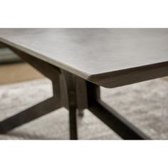 a close up of a table on a carpeted floor with a window in the background