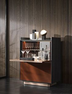 a bar with several glasses and bottles on the counter in front of a striped wall