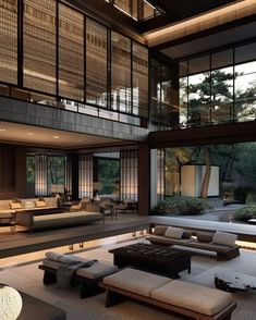 a living room filled with lots of furniture and large glass windows on top of it