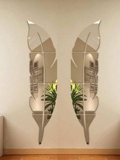 two mirrors that are next to each other on the wall in front of a plant