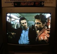 two men standing in front of a tv with the words fightclub on it